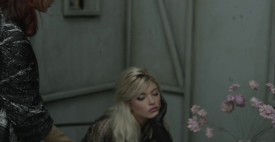 a woman sitting at a table with a vase of flowers