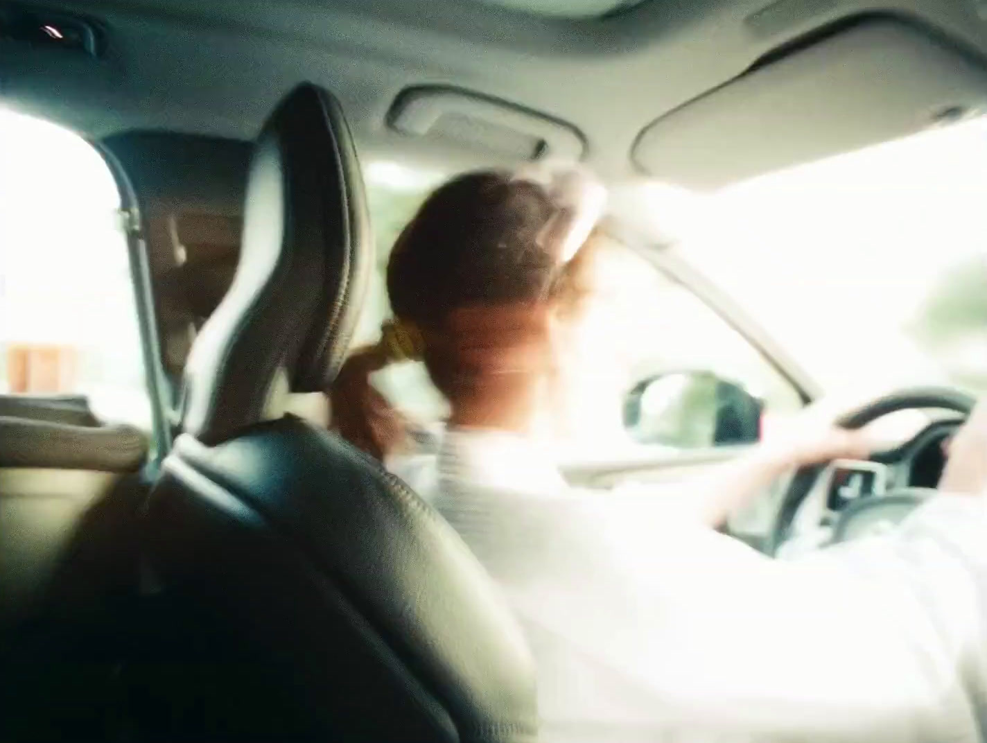 a woman driving a car while holding a cell phone