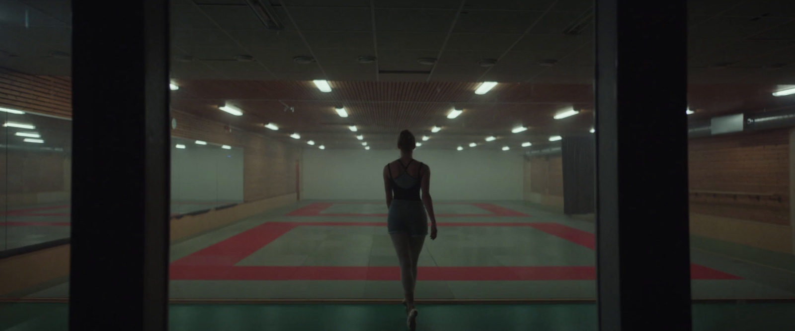 a woman is walking through a dimly lit room