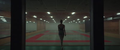 a woman is walking through a dimly lit room