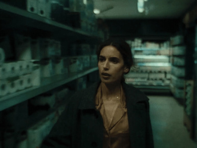 a woman standing in a room with lots of shelves