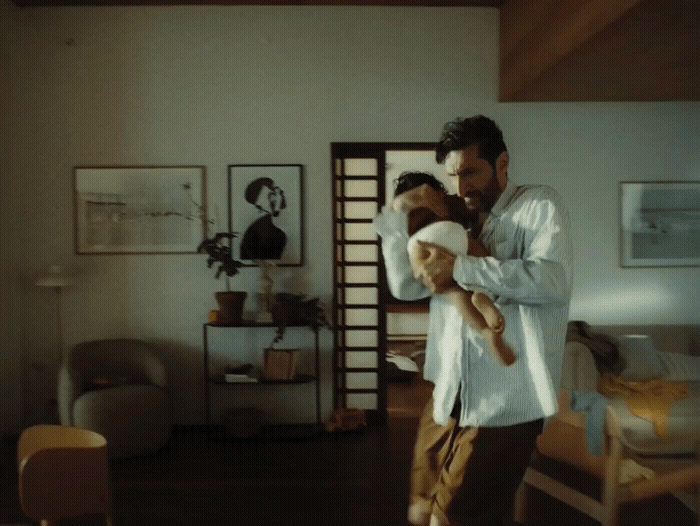 a man holding a child in a living room