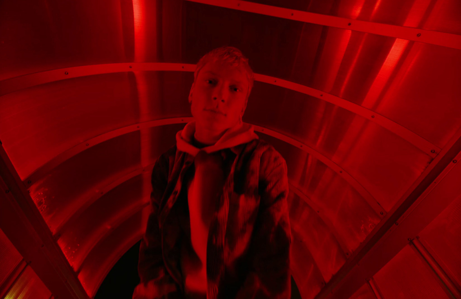 a man standing in a red light tunnel