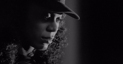 a black and white photo of a woman wearing a hat