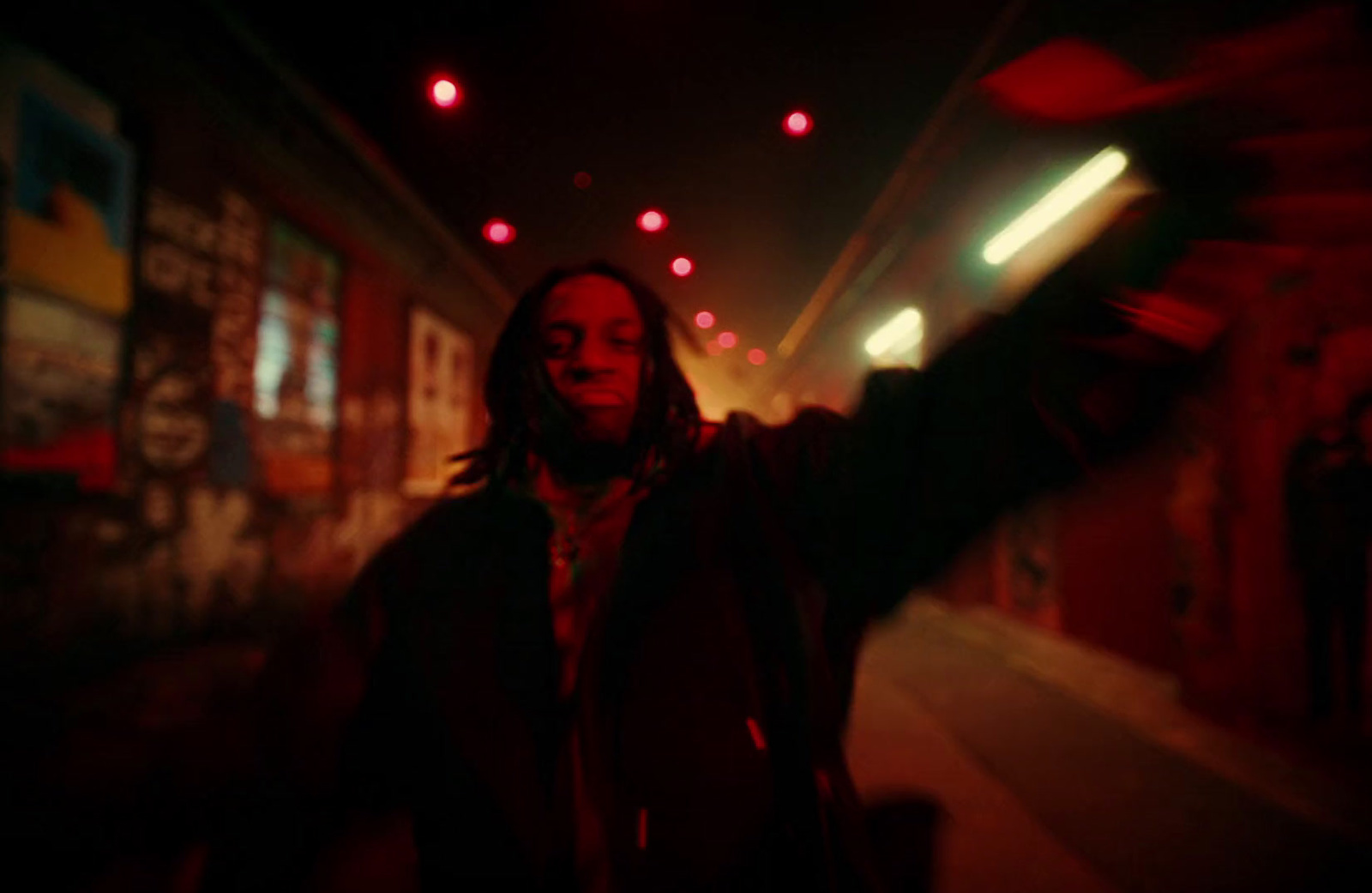 a man with long hair and dreadlocks standing in a tunnel