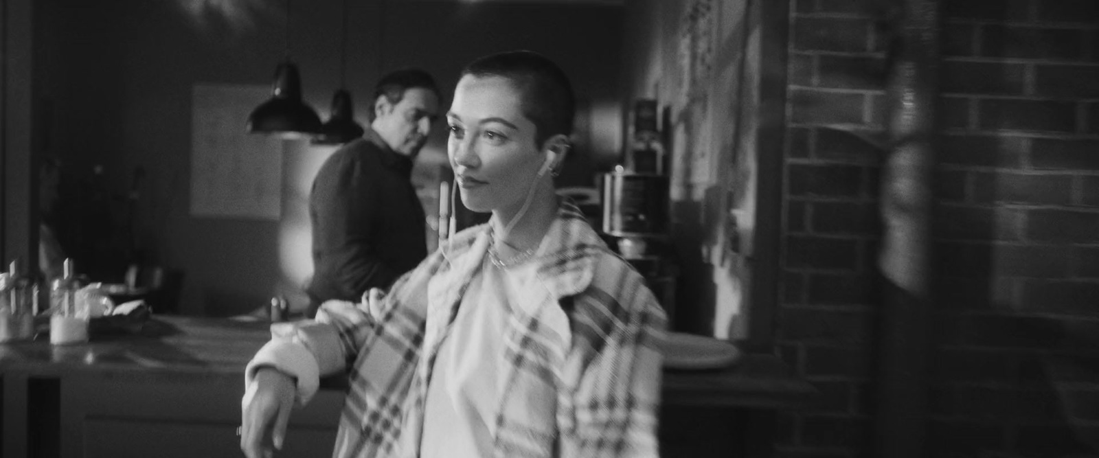 a black and white photo of a man standing in a kitchen