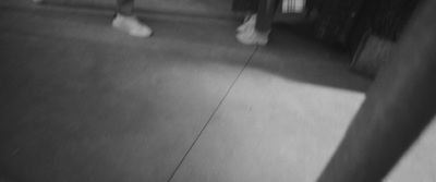 a black and white photo of people walking down a sidewalk