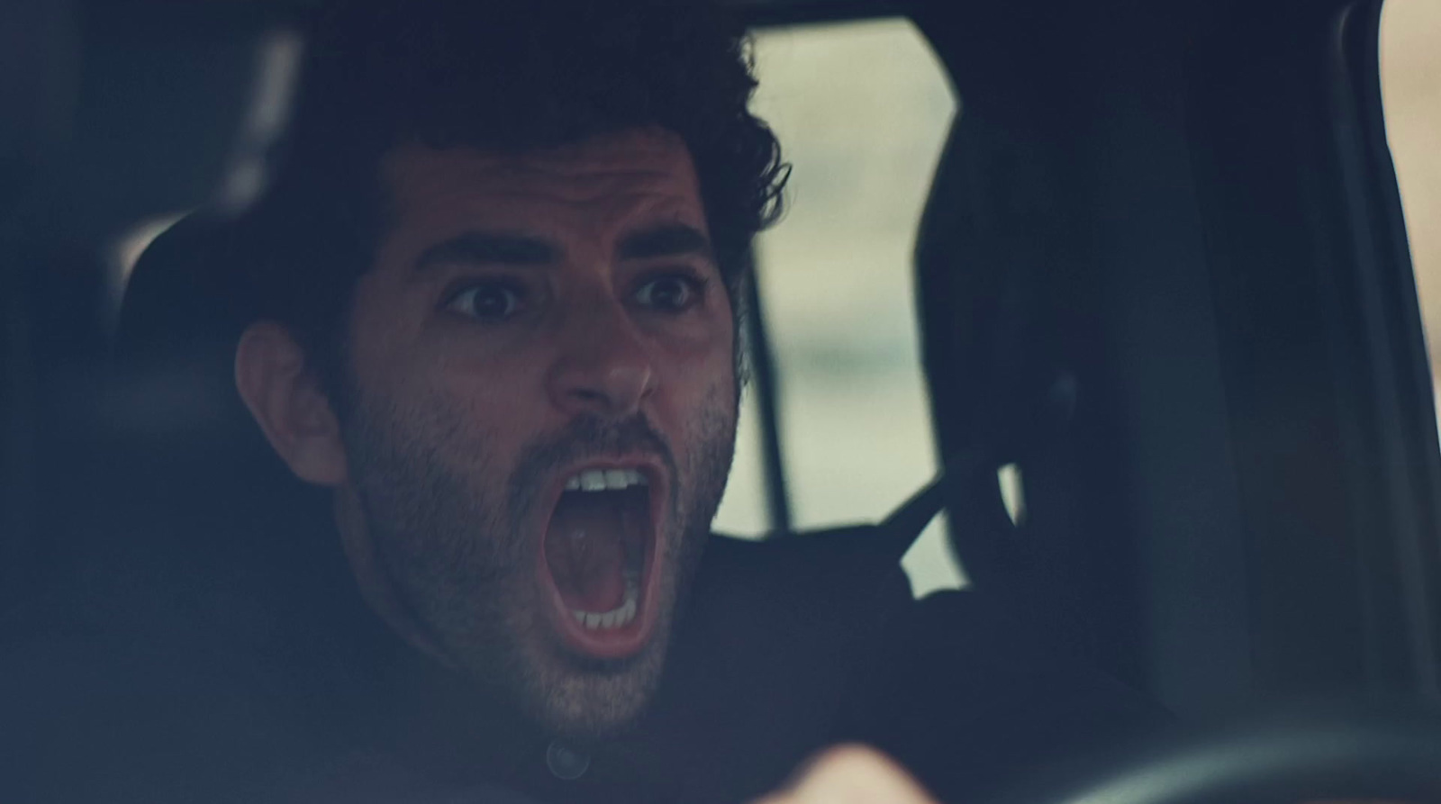 a man in a car with his mouth open