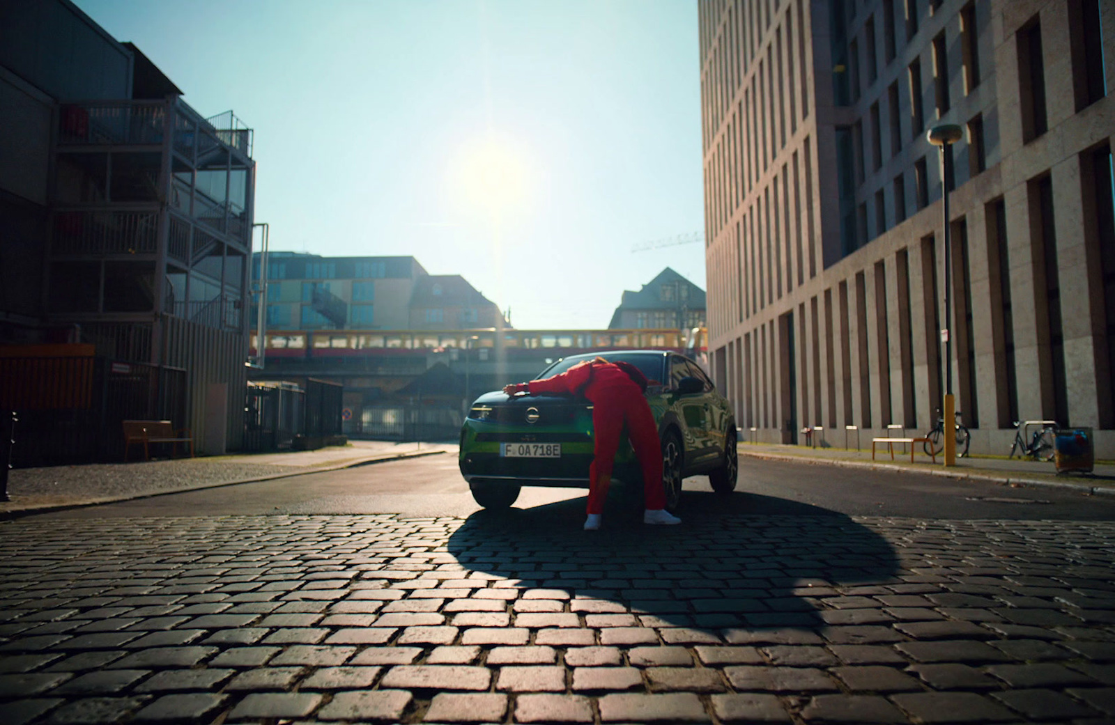 a person standing next to a car on a brick road