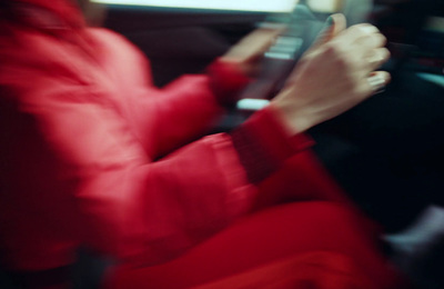 a woman driving a car while holding a cell phone