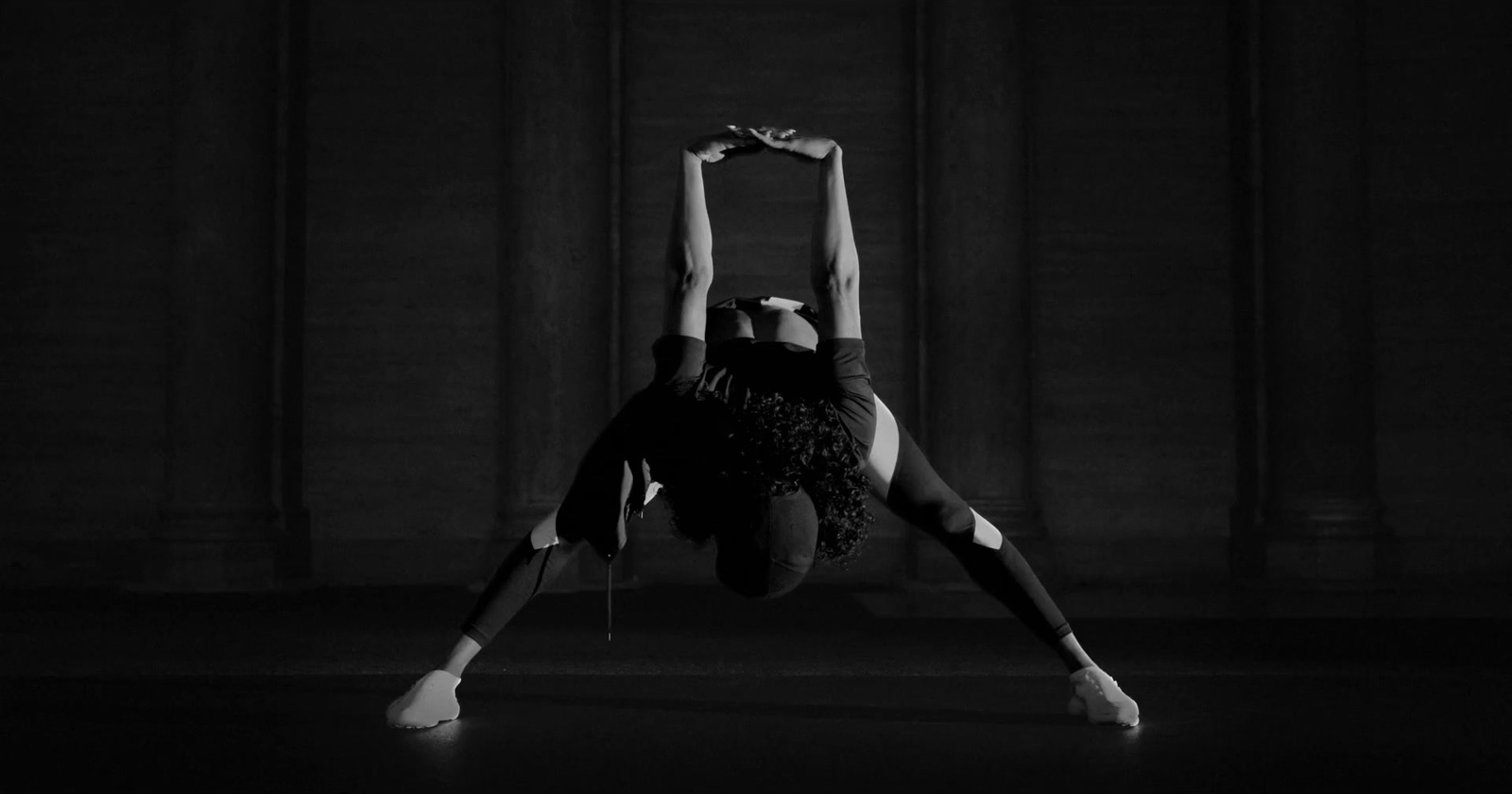 a woman doing a handstand in a dark room