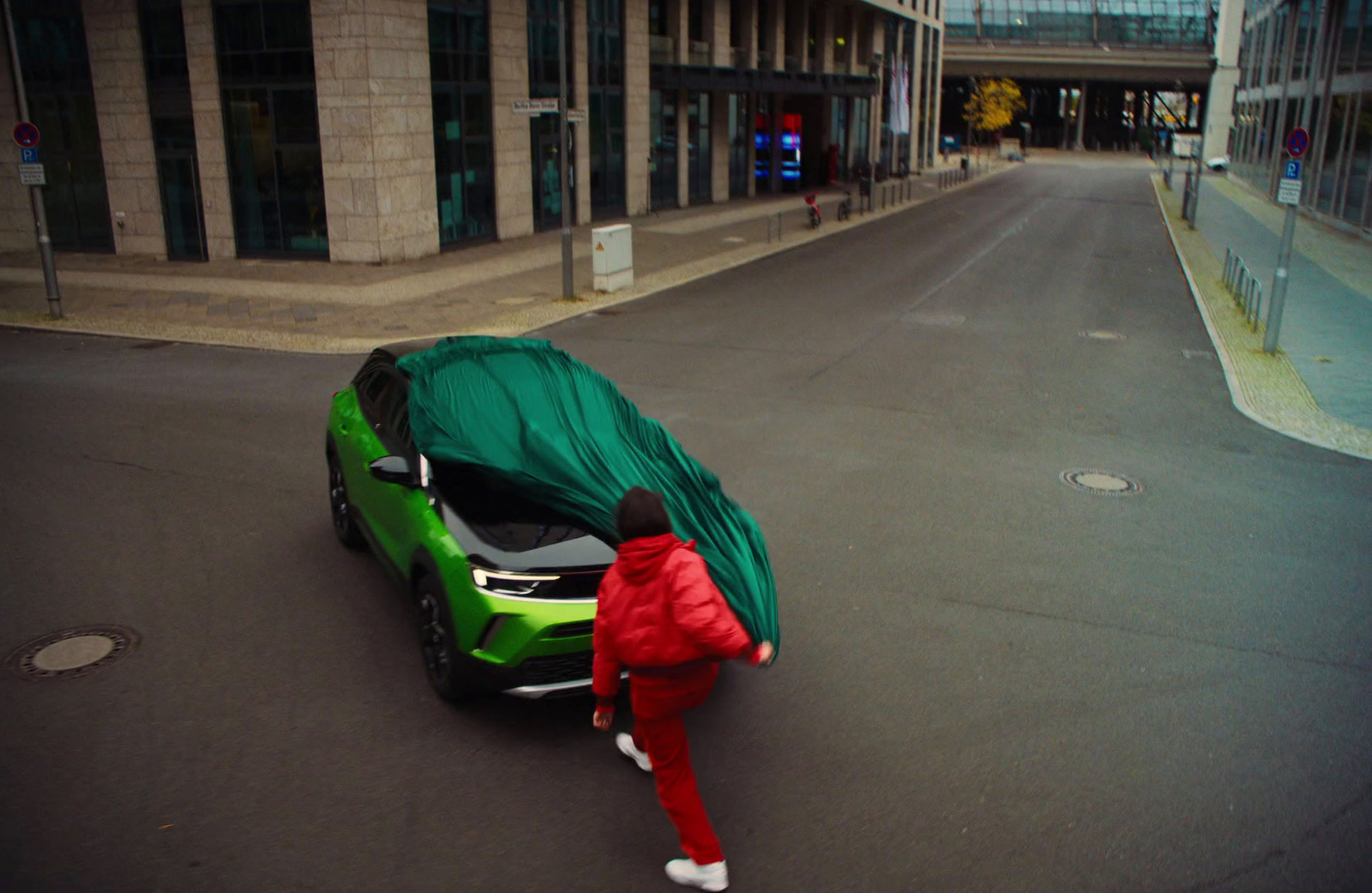 a person in a red suit pushing a green car