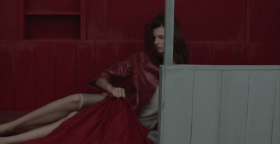 a woman in a red dress sitting on the floor