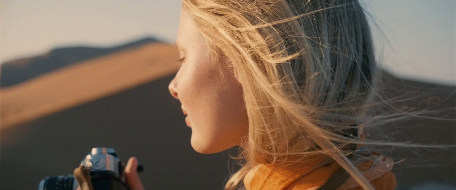 a woman holding a camera in her right hand