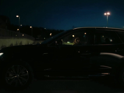 a black suv parked in a parking lot at night