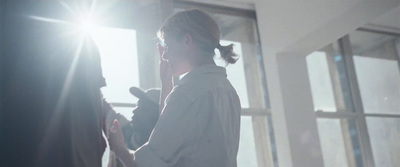 a woman standing in front of a window holding a cell phone