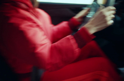 a woman sitting in a car holding a cell phone