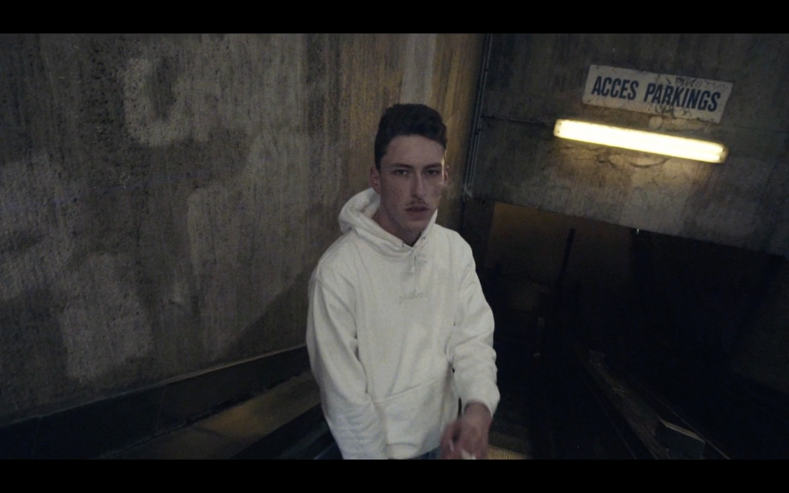 a man sitting on an escalator in a building