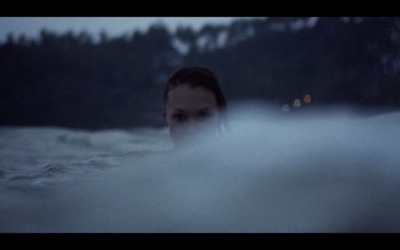 a woman in a hot tub with trees in the background