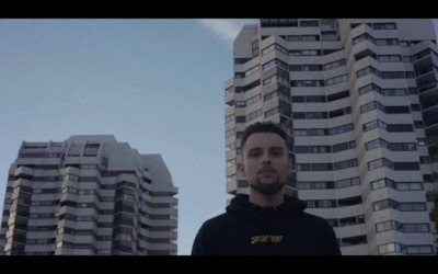 a man standing in front of tall buildings