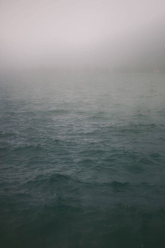 a large body of water covered in fog