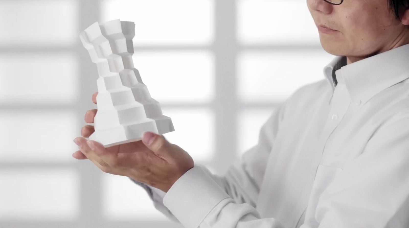 a woman holding a model of a building