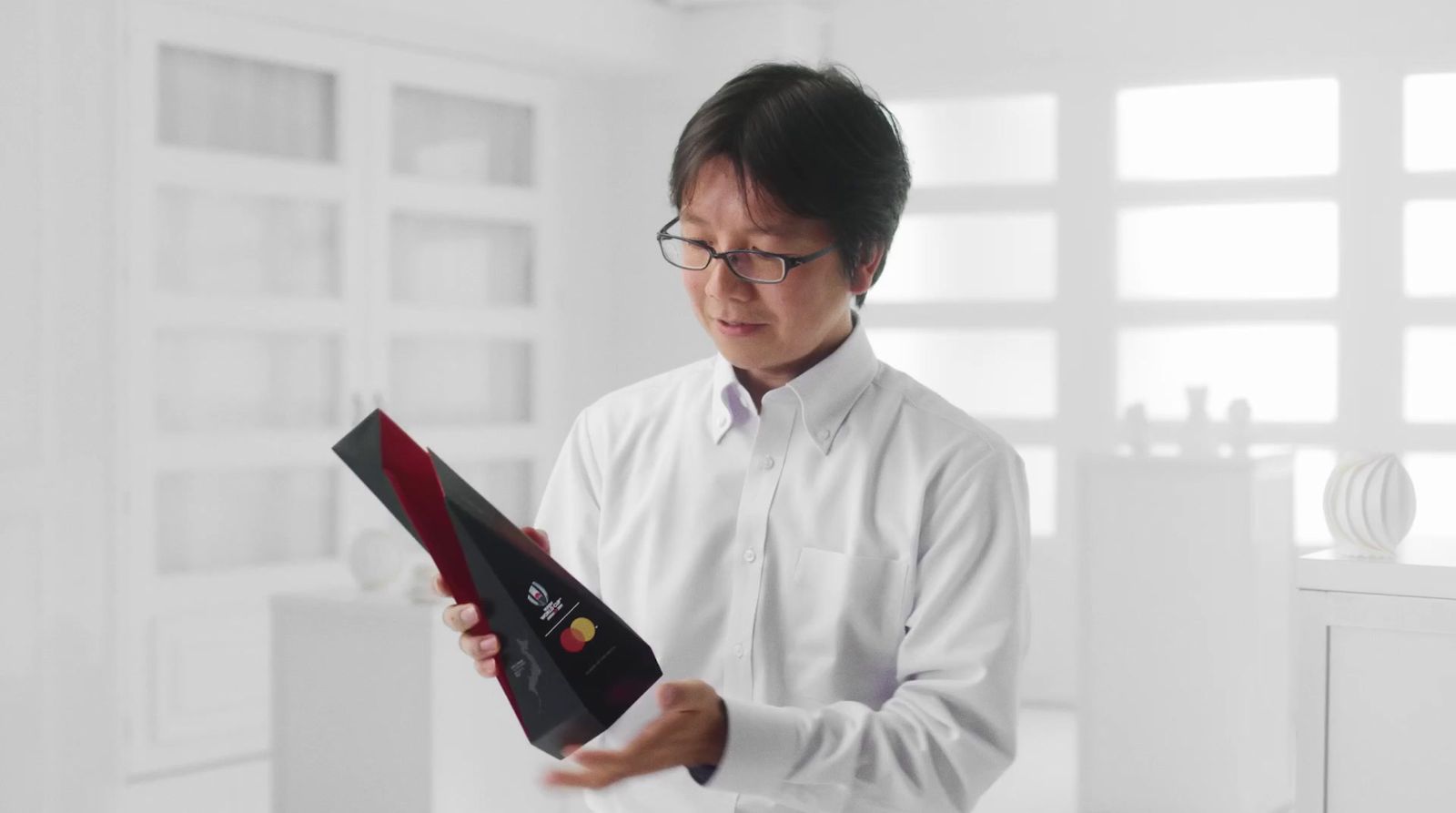 a man in a white shirt is holding a piece of paper