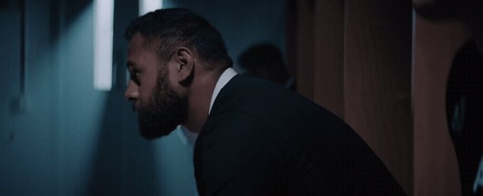 a man in a suit and tie standing in a hallway