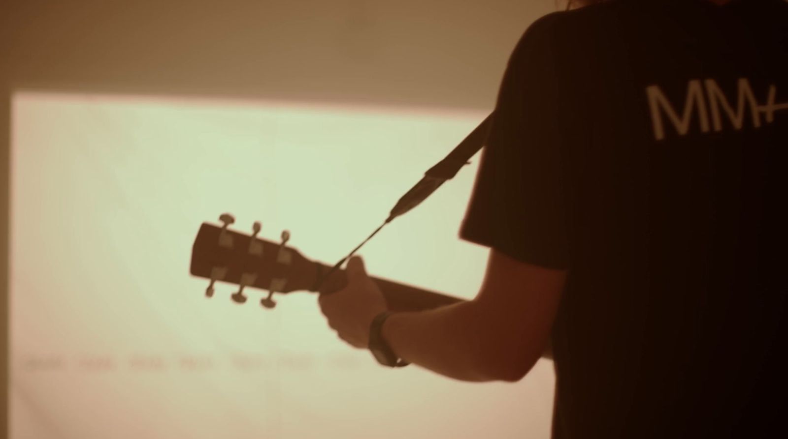 a man with a guitar strap around his neck