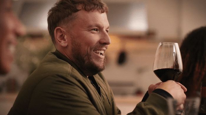 a man holding a glass of red wine