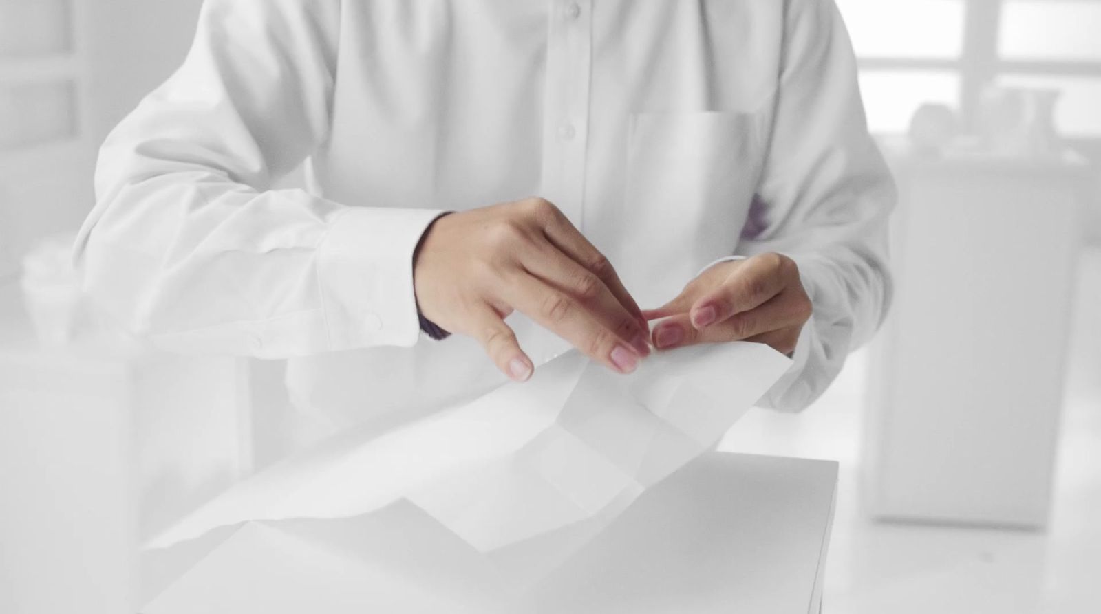 a man in a white shirt is holding a piece of paper