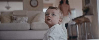 a young boy sitting on the floor in a living room