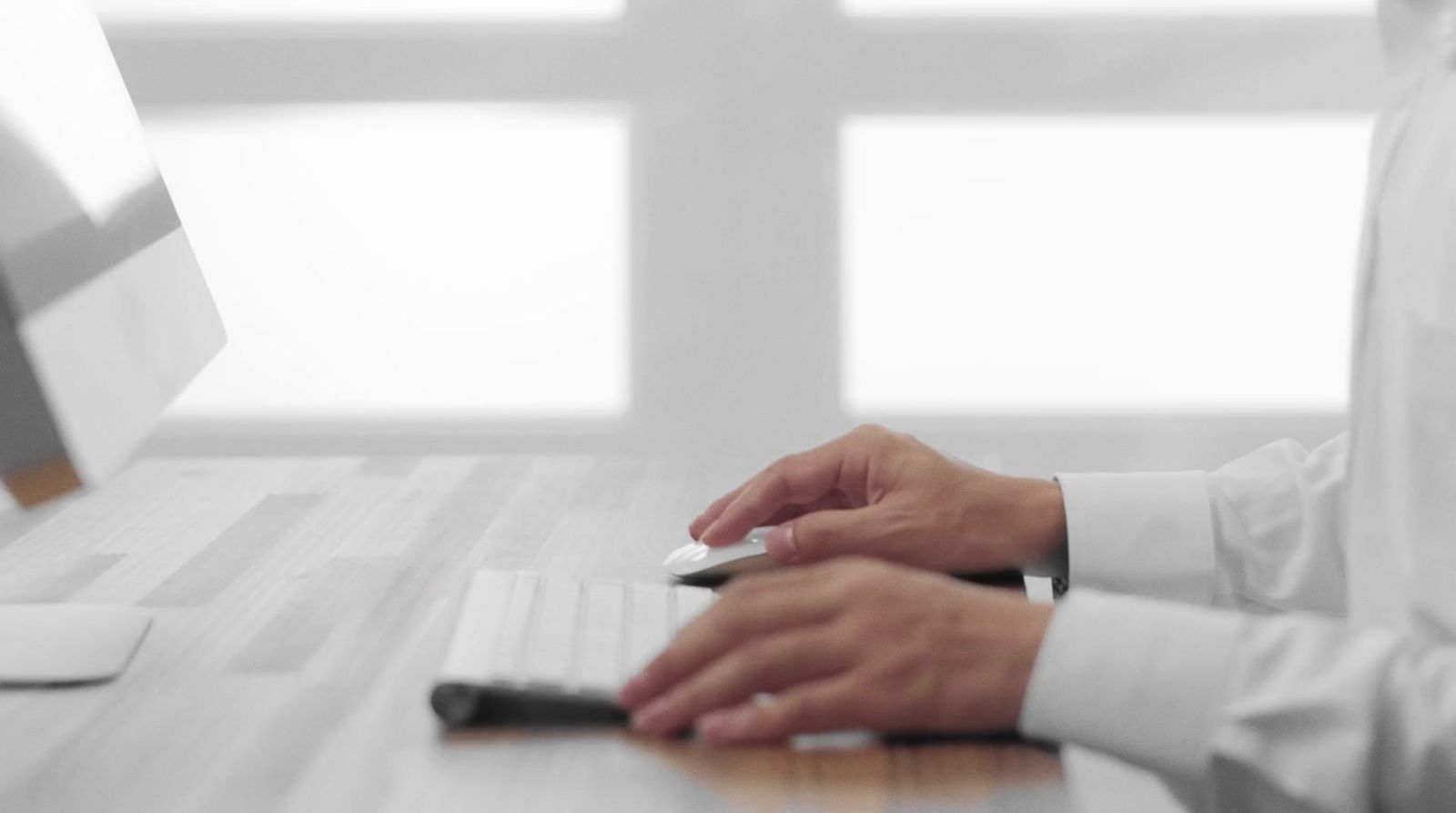 a person sitting at a desk using a computer