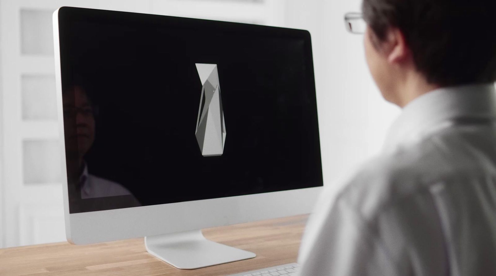 a man looking at a computer screen with a tie on it