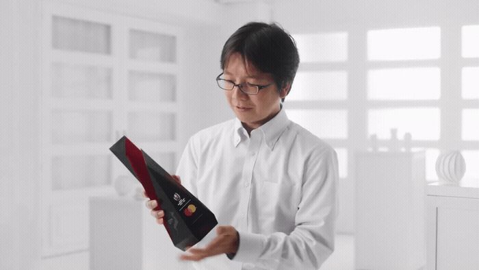 a man in a white shirt holding a black box