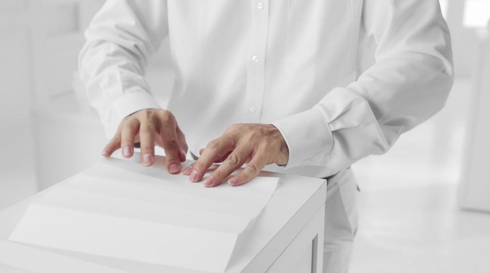 a man in a white shirt is holding a white box