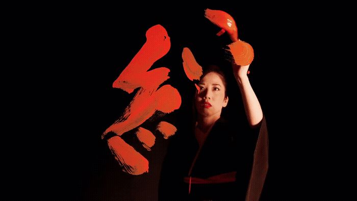 a woman holding up a pair of orange scissors