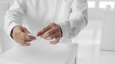 a man in a white shirt is holding a cigarette