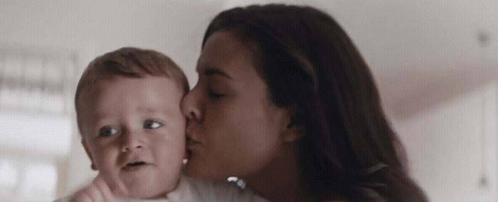 a woman kissing a baby with a surprised look on her face