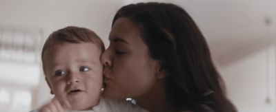 a woman kissing a baby with a surprised look on her face