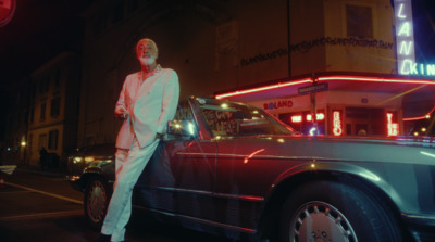 a man standing next to a car on a city street