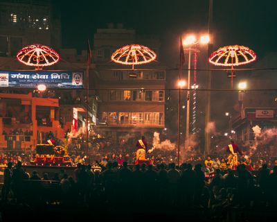 a crowd of people standing around a street at night