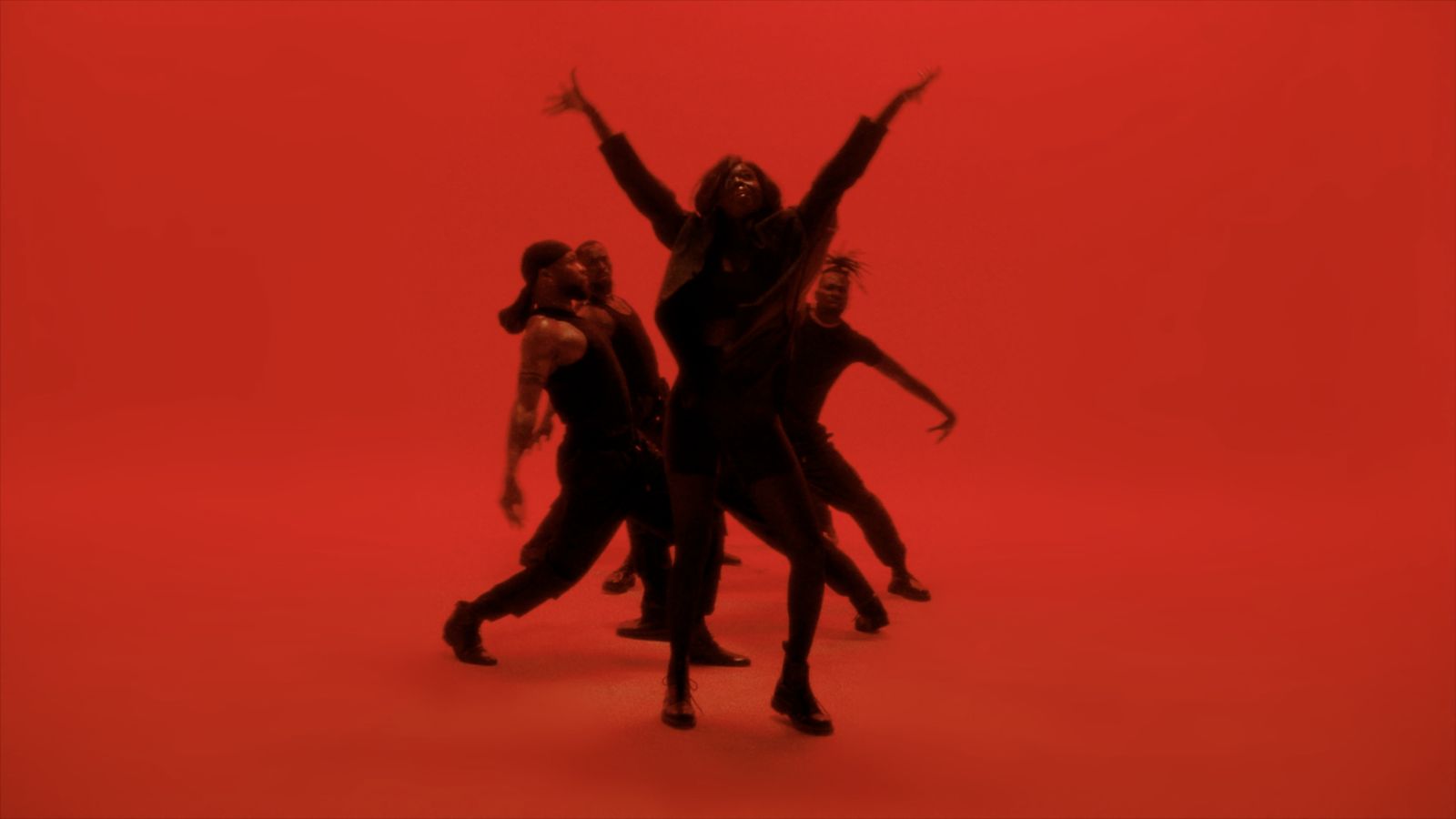 a group of people standing in front of a red background