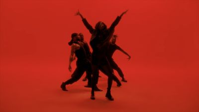 a group of people standing in front of a red background