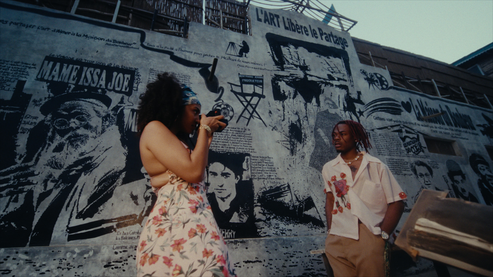 a woman standing next to a man on a cell phone