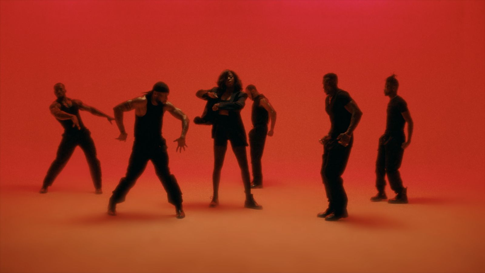 a group of people standing in front of a red background