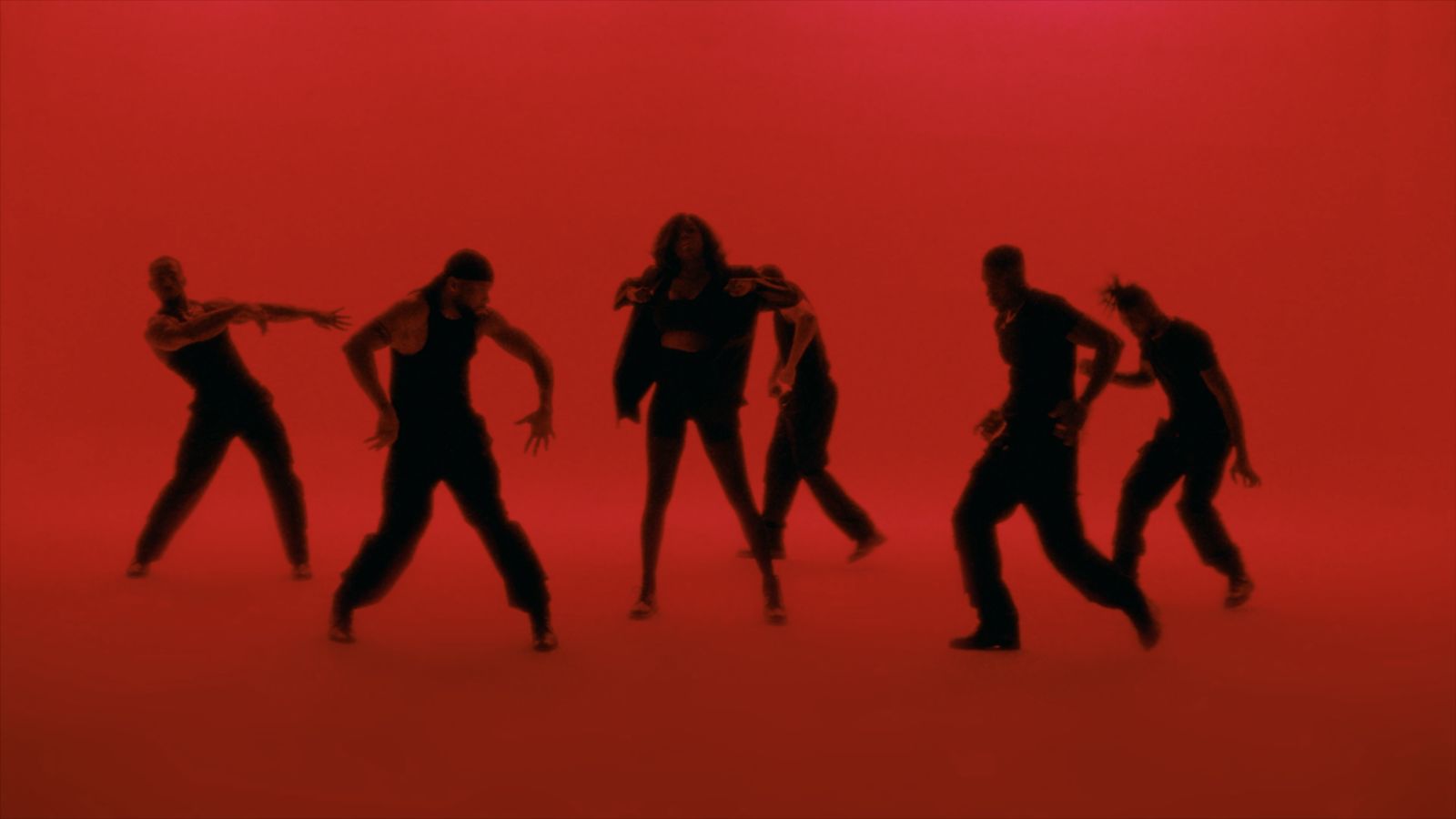 a group of people standing in front of a red background