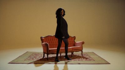 a woman standing on a rug in front of a couch