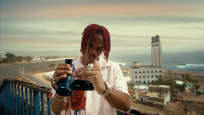 a man with dreadlocks taking a picture with a camera