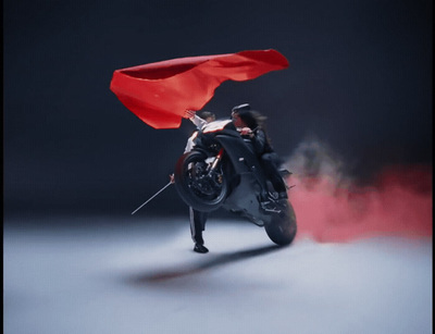 a man riding a motorcycle with a red flag on top of it